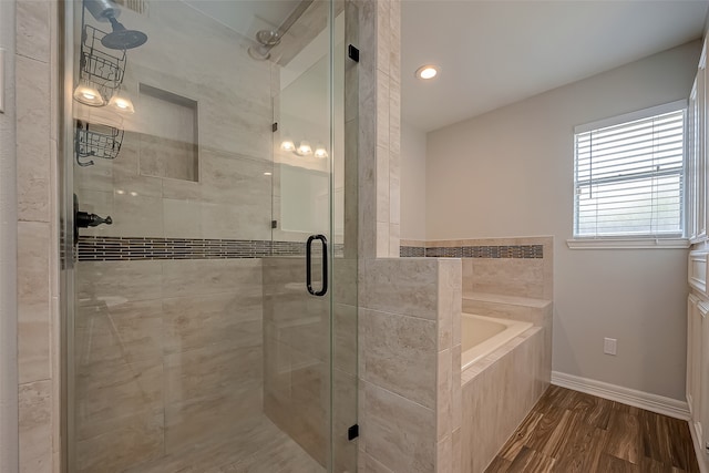 bathroom featuring plus walk in shower and hardwood / wood-style flooring