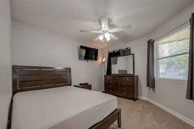 carpeted bedroom featuring a textured ceiling and ceiling fan