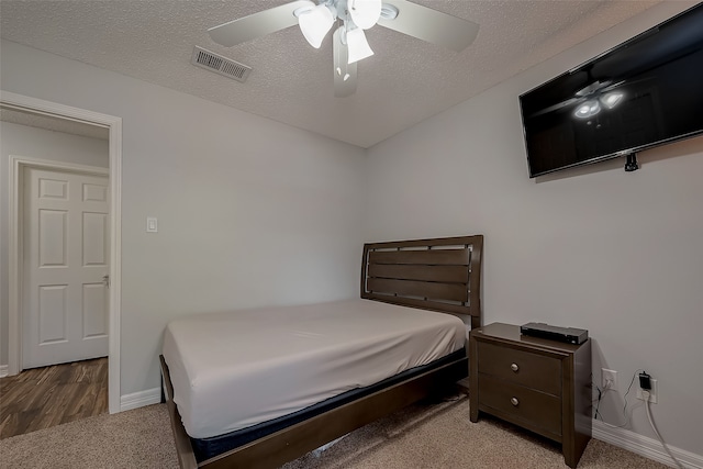 bedroom featuring a textured ceiling, wood-type flooring, and ceiling fan