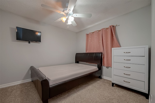 carpeted bedroom featuring ceiling fan and a textured ceiling