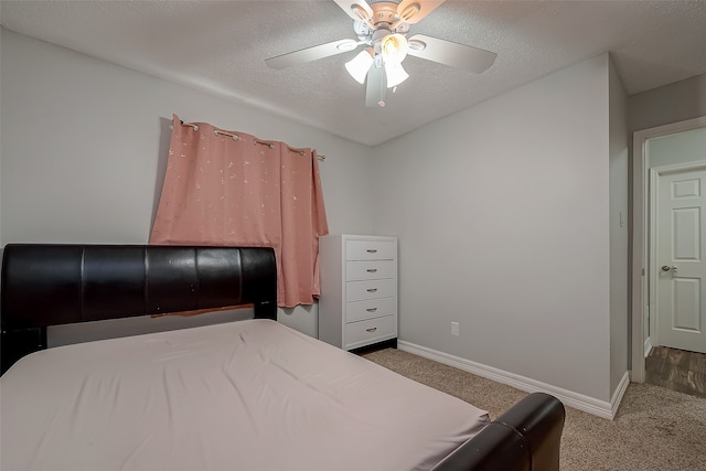 carpeted bedroom with ceiling fan and a textured ceiling