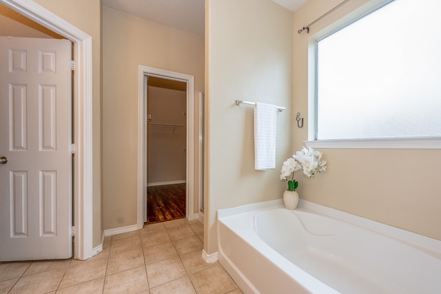 bathroom with tile patterned floors and a washtub