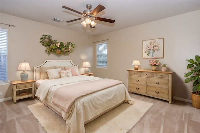 carpeted bedroom with multiple windows and ceiling fan