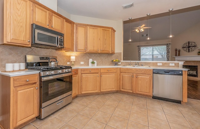 kitchen with light countertops, visible vents, appliances with stainless steel finishes, a sink, and a peninsula