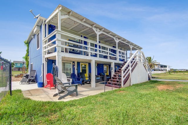 rear view of house featuring a lawn and a patio