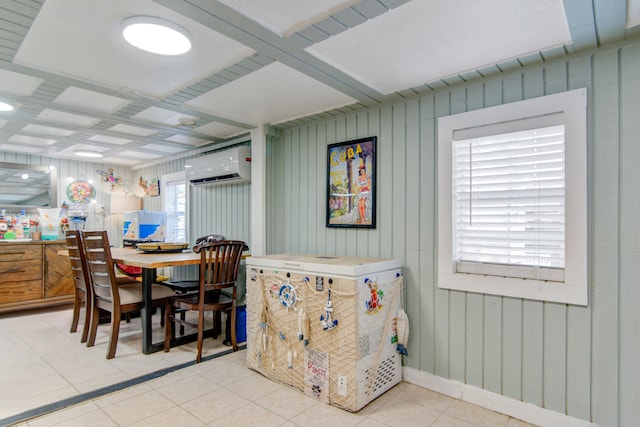 dining area with wooden walls, an AC wall unit, and light tile patterned flooring