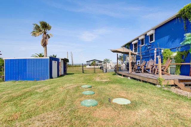 view of yard with a wooden deck and an outbuilding