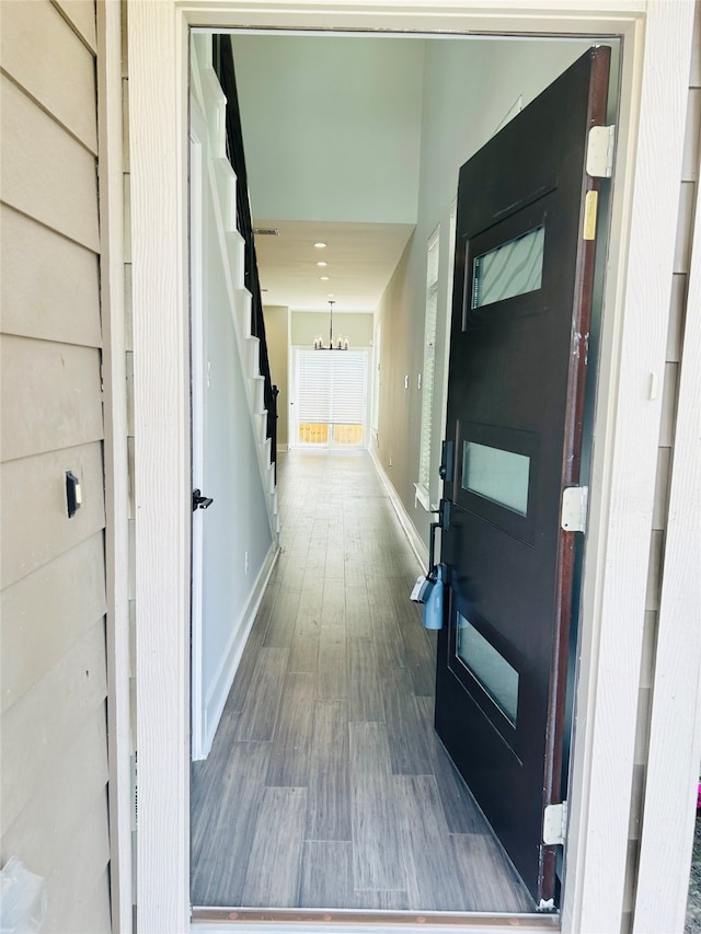 hall featuring hardwood / wood-style flooring and an inviting chandelier