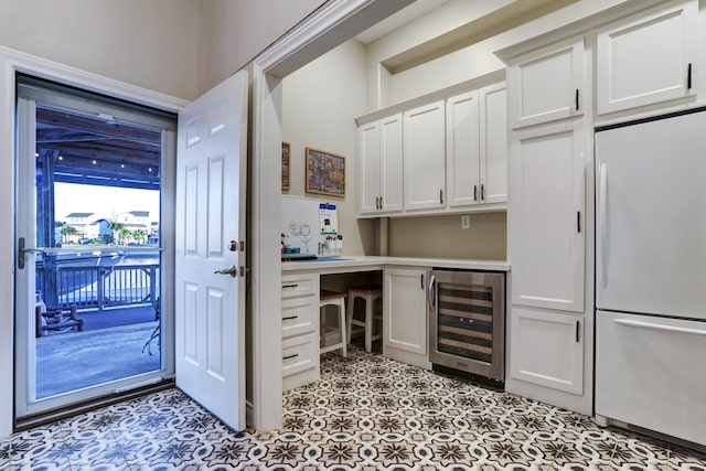 bar with wine cooler, white cabinetry, and white fridge