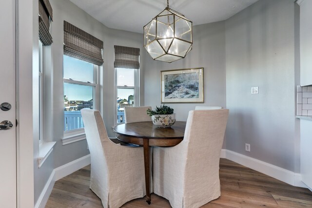 dining space featuring hardwood / wood-style floors and a chandelier