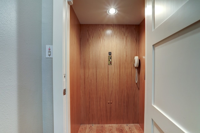 interior details with hardwood / wood-style floors and elevator