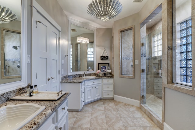 bathroom featuring vanity, a shower with door, a wealth of natural light, and an inviting chandelier