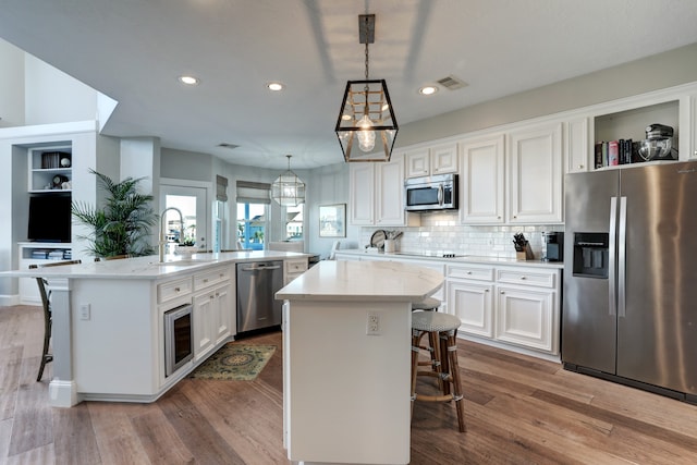 kitchen with a breakfast bar area, a kitchen island with sink, and stainless steel appliances