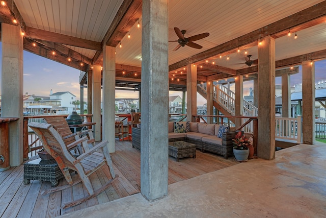 deck at dusk with an outdoor hangout area and ceiling fan