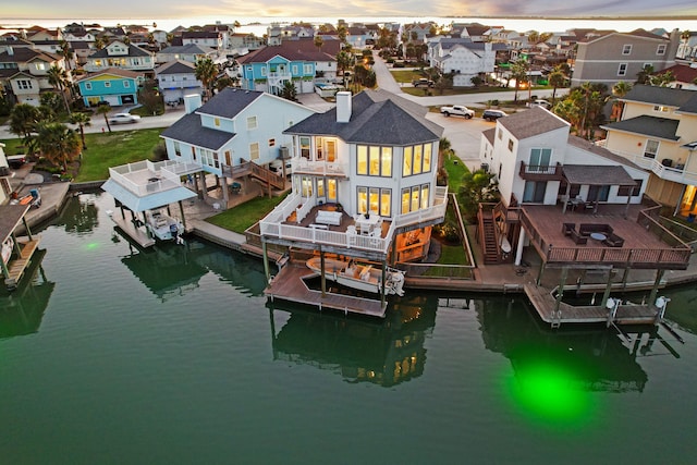 aerial view at dusk featuring a water view