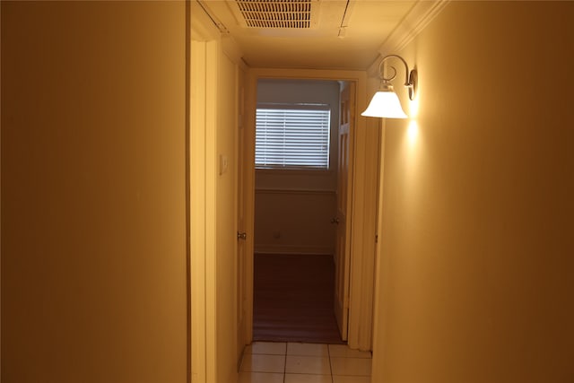 corridor featuring ornamental molding and light tile patterned flooring