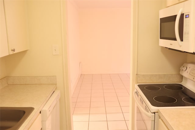 kitchen featuring white cabinetry, white appliances, light tile patterned floors, and sink