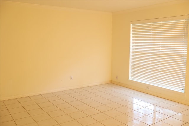 tiled spare room featuring ornamental molding