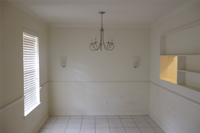 unfurnished dining area with crown molding, an inviting chandelier, and light tile patterned floors