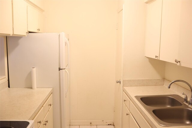 kitchen with white cabinets, white refrigerator, and sink