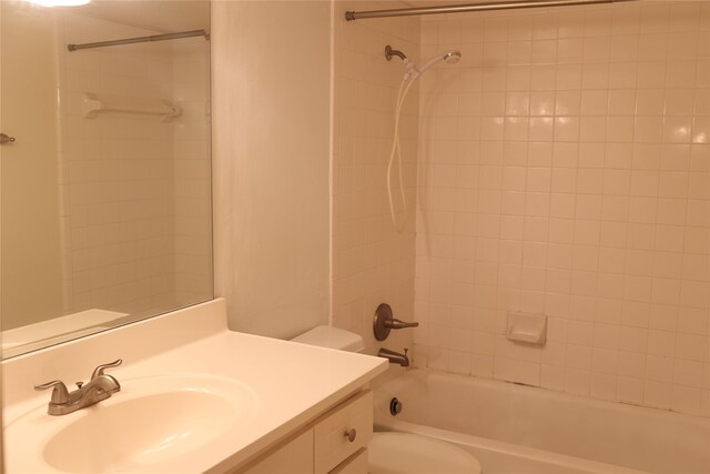 full bathroom with tiled shower / bath combo, vanity, and toilet