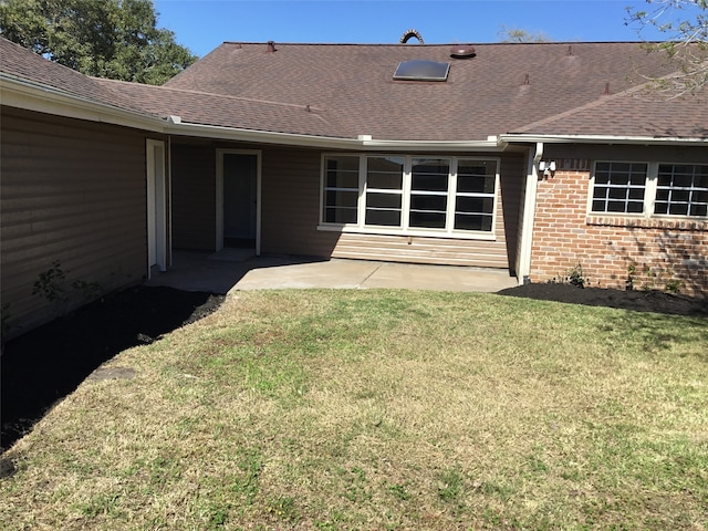 rear view of property with a lawn and a patio