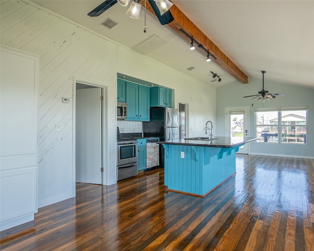 kitchen with dark wood-type flooring, a breakfast bar area, stainless steel appliances, and ceiling fan