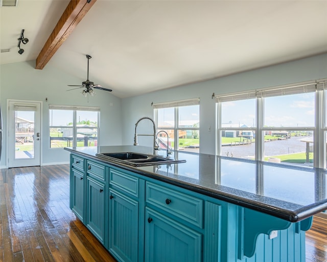 kitchen featuring a center island with sink, blue cabinetry, dark wood-type flooring, sink, and lofted ceiling with beams