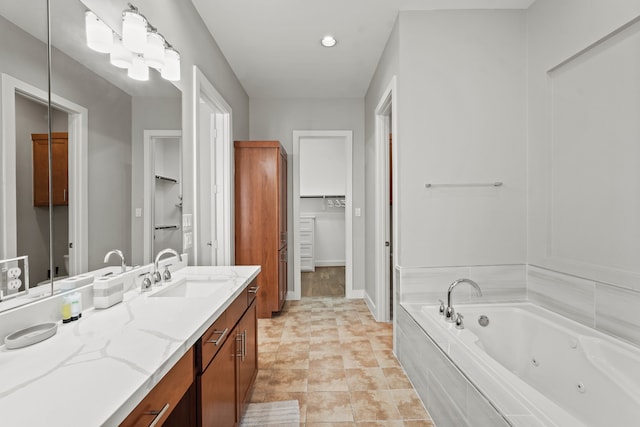 bathroom featuring tiled tub and vanity