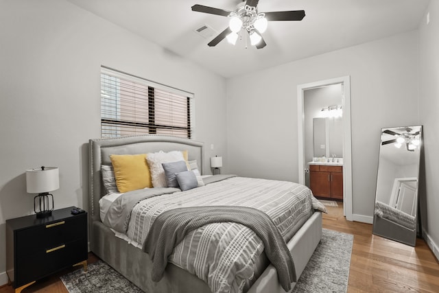 bedroom featuring sink, hardwood / wood-style floors, ensuite bathroom, and ceiling fan