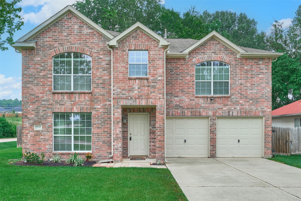 view of property with a garage and a front lawn