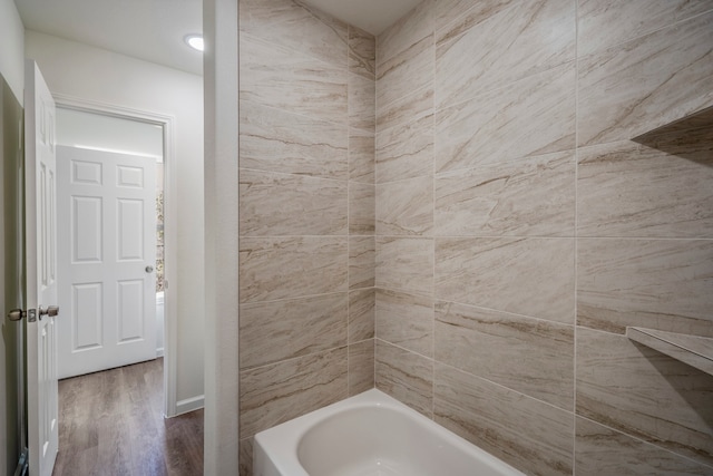 bathroom with tiled shower / bath combo and hardwood / wood-style floors