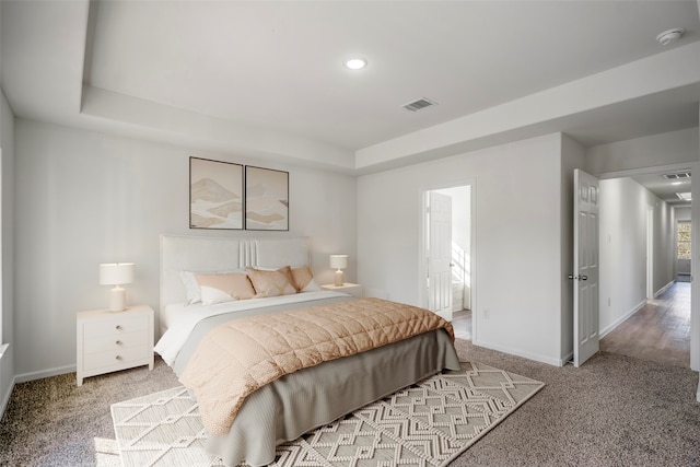 bedroom featuring connected bathroom and light carpet