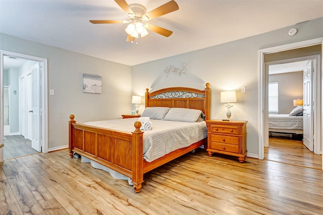 bedroom featuring light wood-type flooring, ensuite bath, and ceiling fan