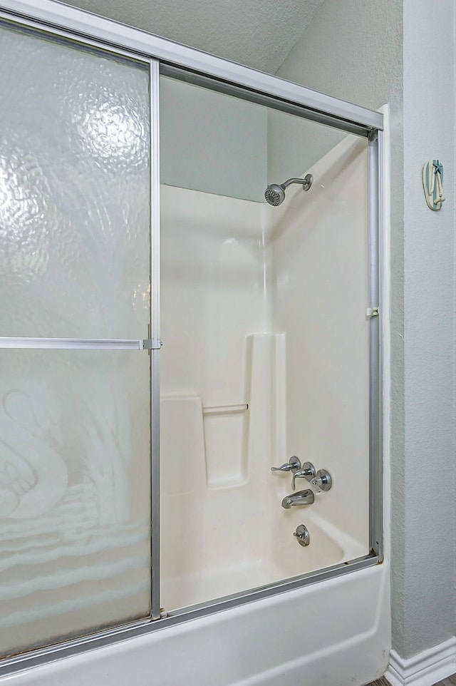 bathroom with bath / shower combo with glass door