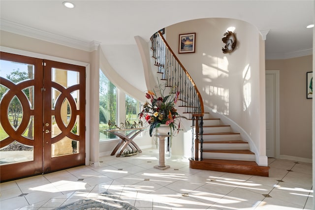 entryway featuring french doors, crown molding, and light tile patterned flooring