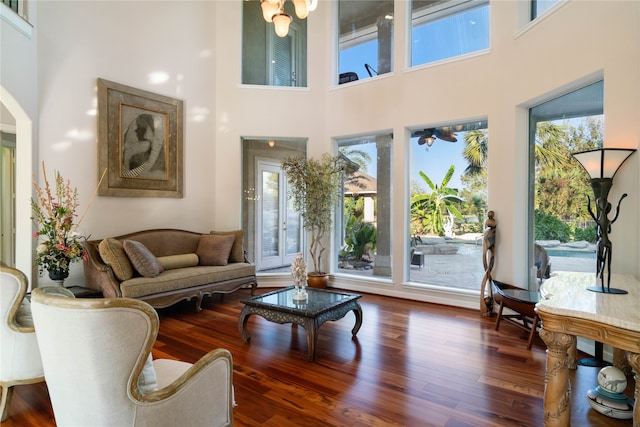 living room featuring hardwood / wood-style flooring and a towering ceiling