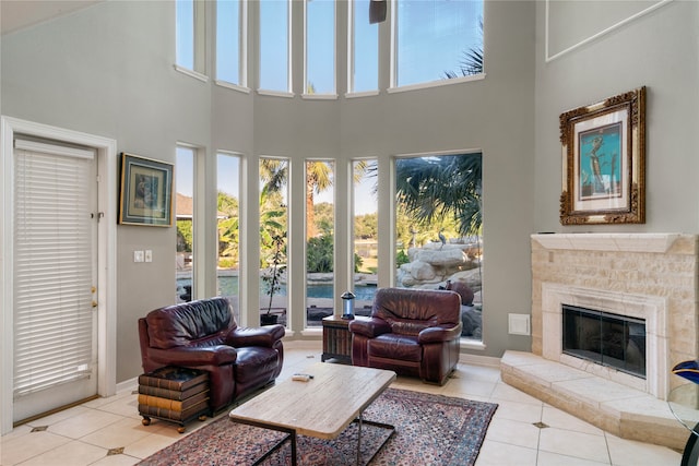 tiled living room featuring a towering ceiling and a fireplace