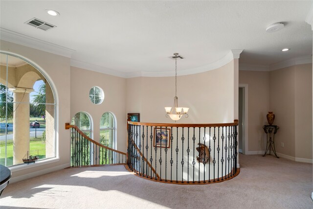 hall with ornamental molding, a chandelier, and light carpet