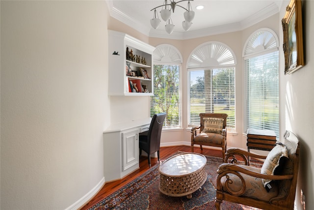 living area featuring an inviting chandelier, hardwood / wood-style flooring, and crown molding