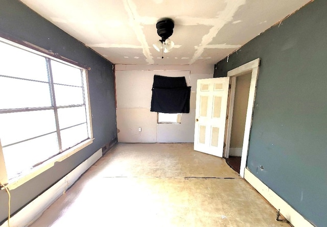 unfurnished room featuring concrete floors and baseboard heating