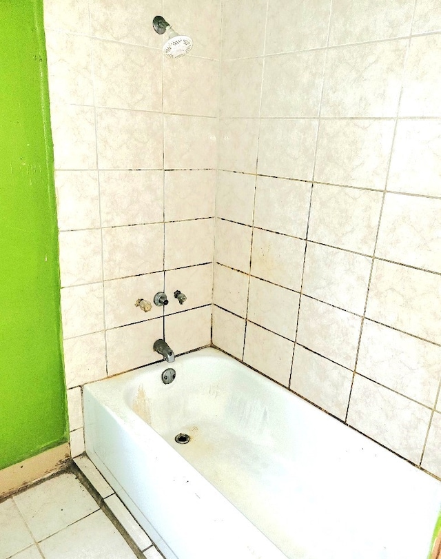 bathroom featuring baseboards, a shower, a bathing tub, and tile patterned floors