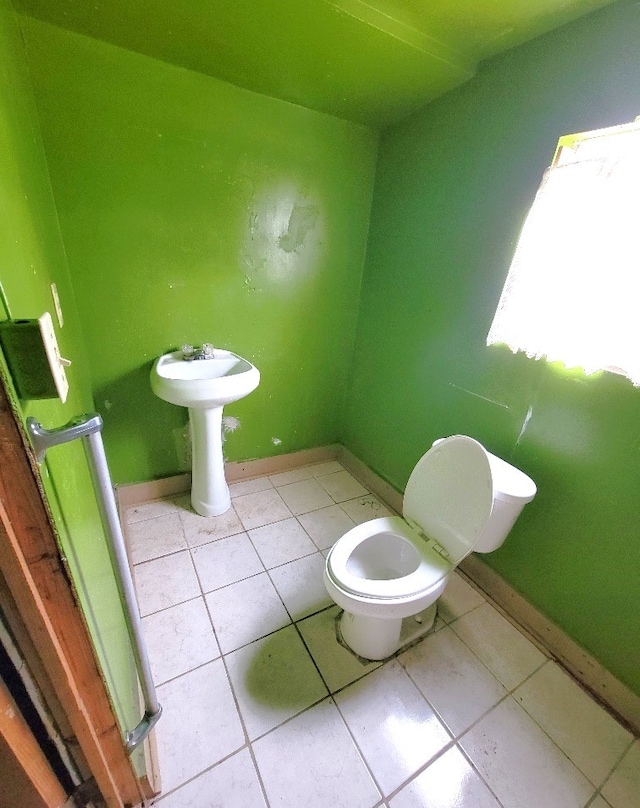 bathroom featuring tile patterned flooring, toilet, and baseboards