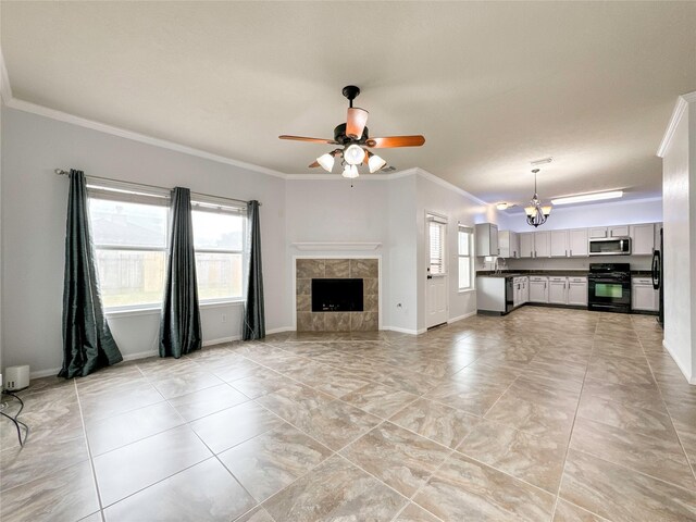 unfurnished living room featuring ceiling fan with notable chandelier, a tile fireplace, sink, and ornamental molding