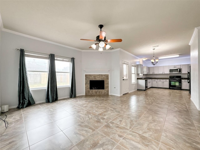 unfurnished living room featuring ceiling fan with notable chandelier, ornamental molding, a tiled fireplace, and sink