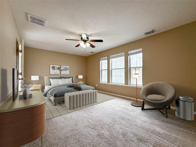 carpeted bedroom featuring ceiling fan and a textured ceiling