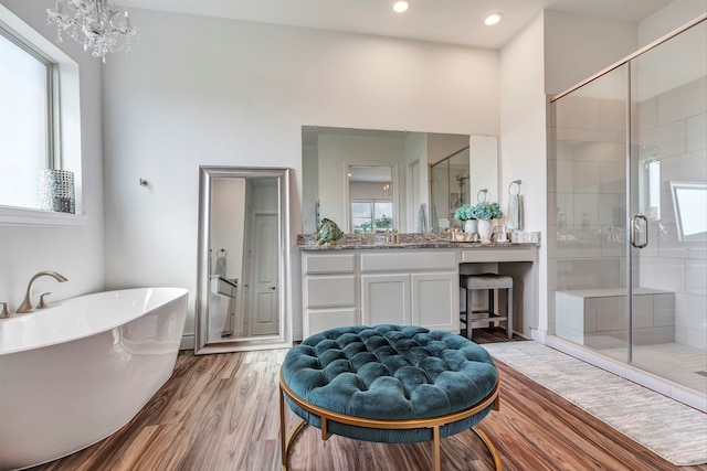 bathroom with independent shower and bath, vanity, and hardwood / wood-style floors