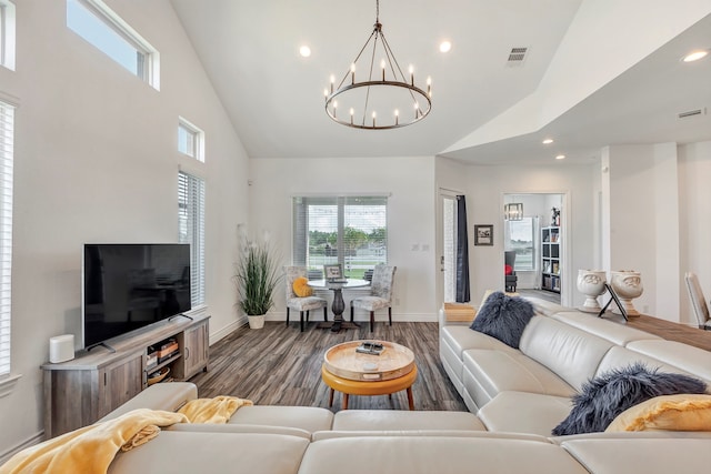 living room featuring a notable chandelier, high vaulted ceiling, and hardwood / wood-style floors