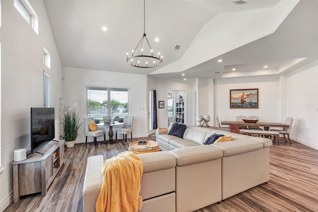 living room featuring an inviting chandelier, high vaulted ceiling, and hardwood / wood-style flooring