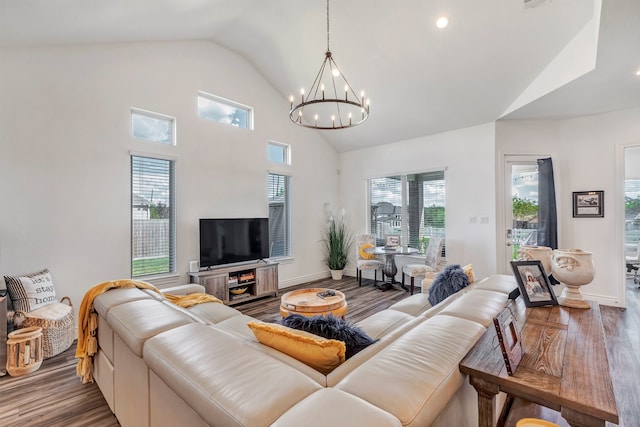 living room featuring wood-type flooring, a chandelier, and high vaulted ceiling